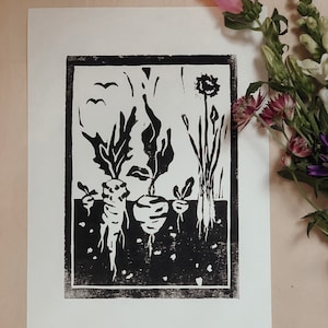 Könnte beinhalten: Schwarz-weißer Linolschnitt, der eine Gartenszene mit drei großen Wurzelgemüsen, einem Löwenzahn und zwei Vögeln im Flug zeigt.