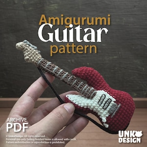 Puede incluir: Una guitarra roja y blanca de ganchillo con una correa negra. La guitarra tiene un mástil y clavijero marrones. La imagen incluye el texto "Amigurumi Guitar pattern" y "Archive PDF".