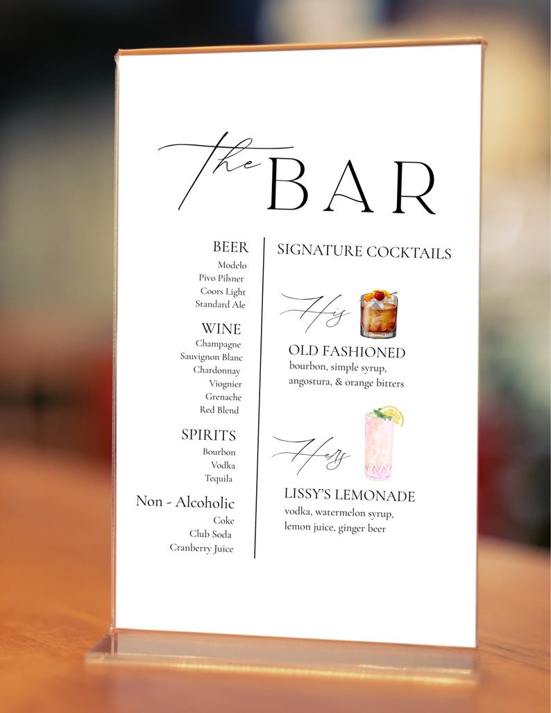 May include: A clear acrylic bar menu with the words "The BAR" in elegant script. The menu lists beer, wine, spirits, and non-alcoholic beverages. Signature cocktails include an Old Fashioned and Lissy's Lemonade.