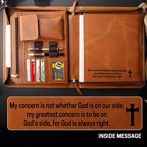 May include: Open brown leather portfolio with multiple compartments, including card slots, pen holders, and a notepad. The interior features the text "My concern is not whether God is on our side; my greatest concern is to be on God's side, for God is always right." and a cross.
