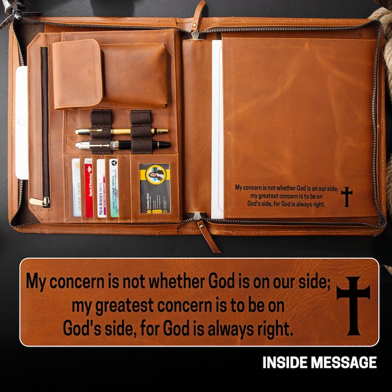 May include: Open brown leather portfolio with multiple compartments, including card slots, pen holders, and a notepad. The interior features the text "My concern is not whether God is on our side; my greatest concern is to be on God's side, for God is always right." and a cross.