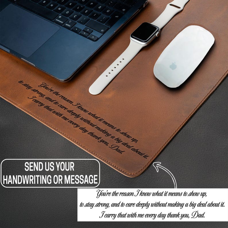 May include: A brown leather desk mat with a laptop, a white Apple Watch, and a white Apple mouse. The mat has engraved text and a white box that says "SEND US YOUR HANDWRITING OR MESSAGE".