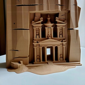 May include: A 3D printed model of the Treasury building in Petra, Jordan. The model is made of brown plastic and shows the intricate details of the facade, including the columns, arches, and carvings.