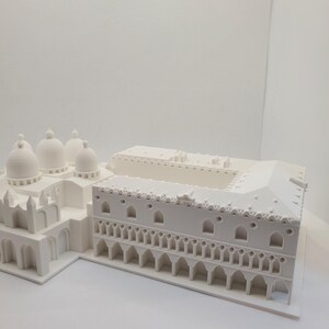 May include: A white 3D printed model of a building with a domed roof and a colonnade.