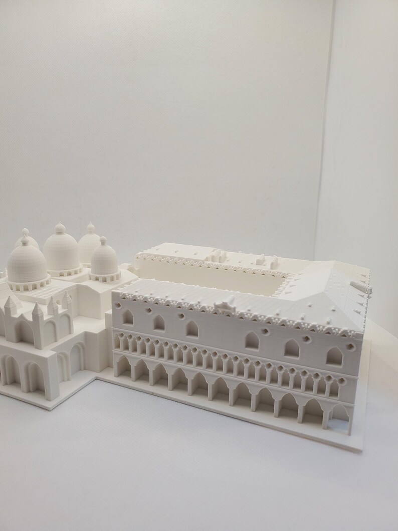 May include: A white 3D printed model of a building with a domed roof and a colonnade.