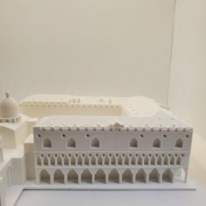 May include: A white 3D printed model of a building with a detailed facade and a domed roof.