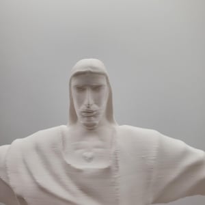 May include: A white plaster sculpture of a person with their arms outstretched. The sculpture is a replica of the famous Christ the Redeemer statue in Rio de Janeiro, Brazil.