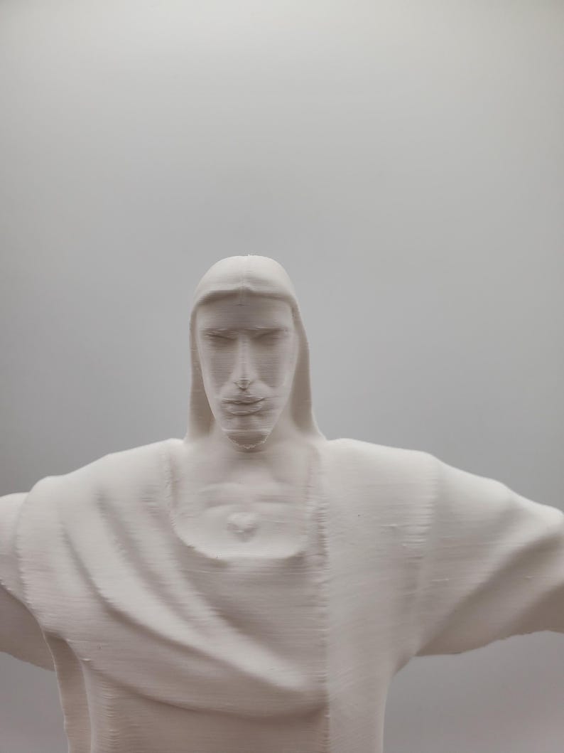 May include: A white plaster sculpture of a person with their arms outstretched. The sculpture is a replica of the famous Christ the Redeemer statue in Rio de Janeiro, Brazil.