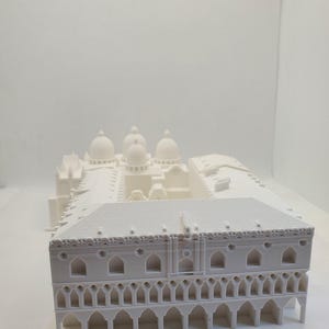 May include: White 3D printed model of a building with a domed roof and arched windows.
