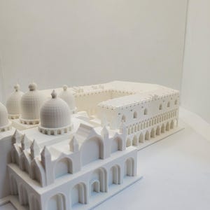 May include: A white 3D printed model of a building with multiple domes and arches.