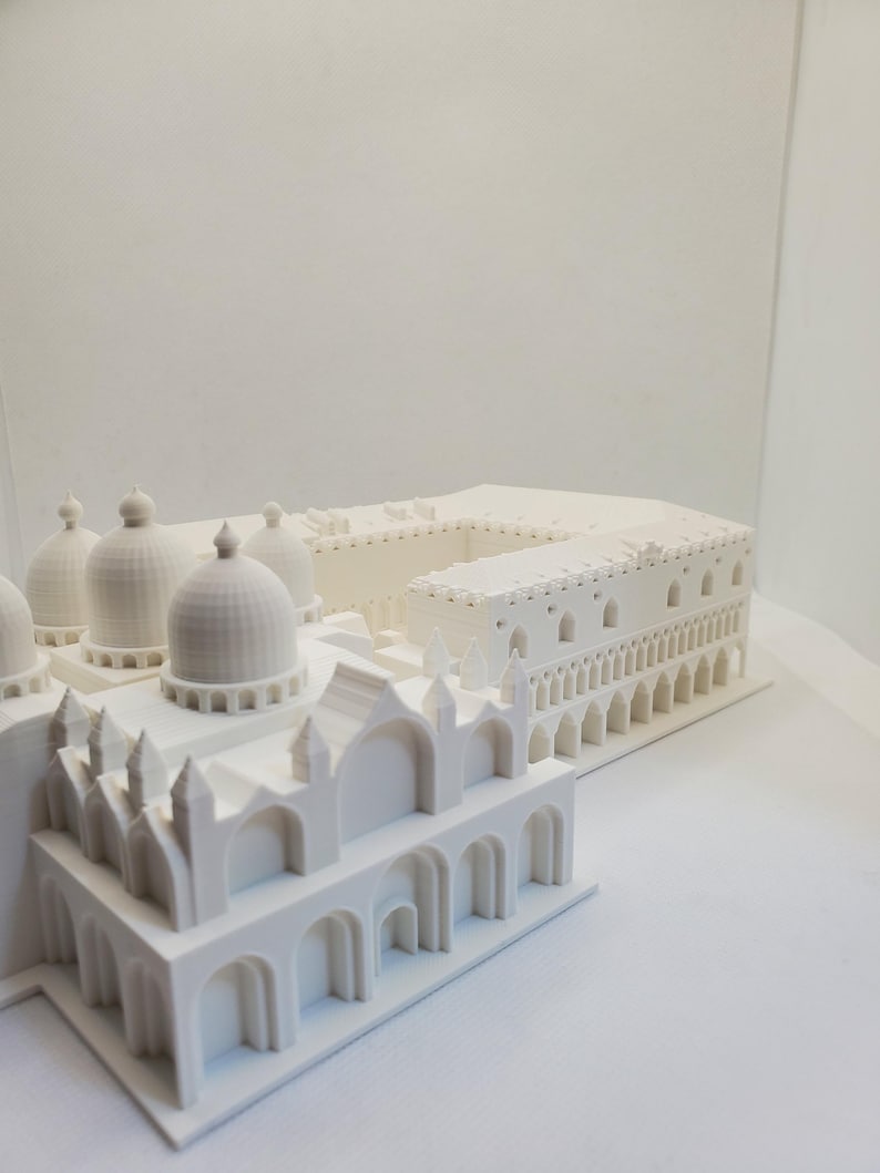 May include: A white 3D printed model of a building with multiple domes and arches.