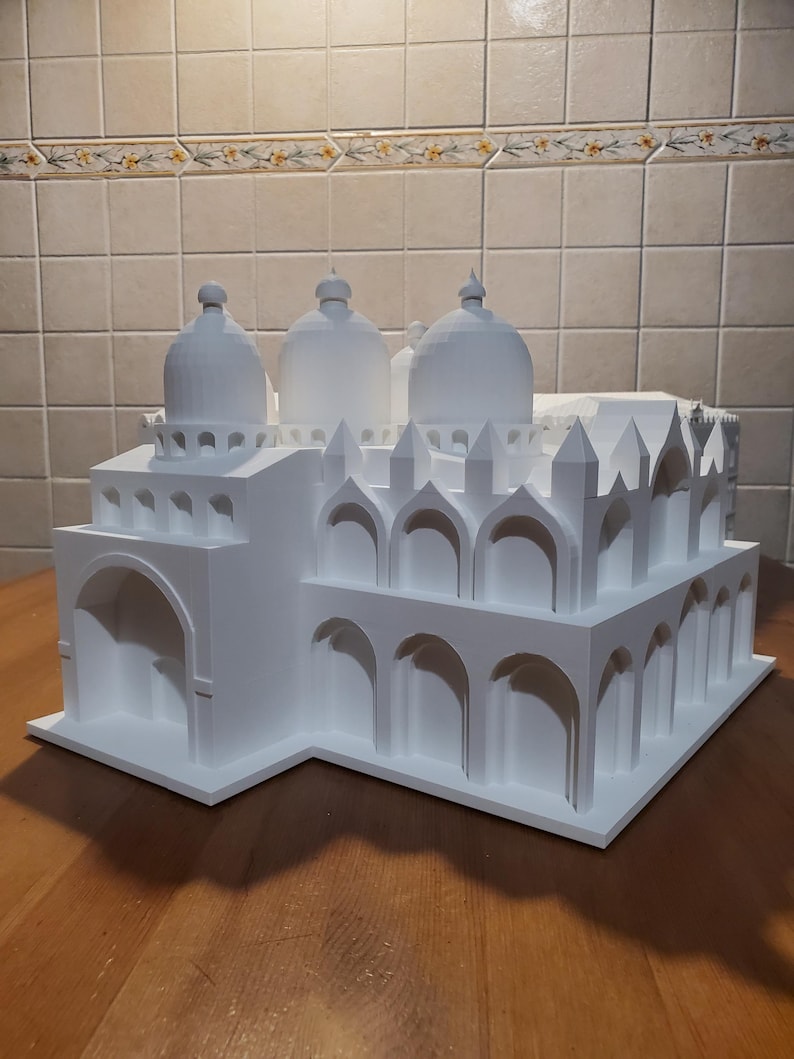 May include: A white 3D printed model of a building with multiple domes and arches. The model is detailed and intricate, showcasing the architectural style of the building.