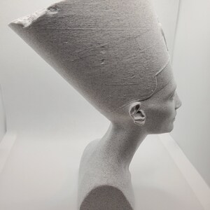 K&ouml;nnte beinhalten: Eine wei&szlig;e B&uuml;ste eines alten &auml;gyptischen K&ouml;nigs mit traditioneller Kopfbedeckung. Die Skulptur ist aus einem strukturierten Material gefertigt, das an Stein erinnert.