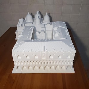 May include: A white 3D printed model of a building with multiple domes and a courtyard. The model is detailed with arches and windows.