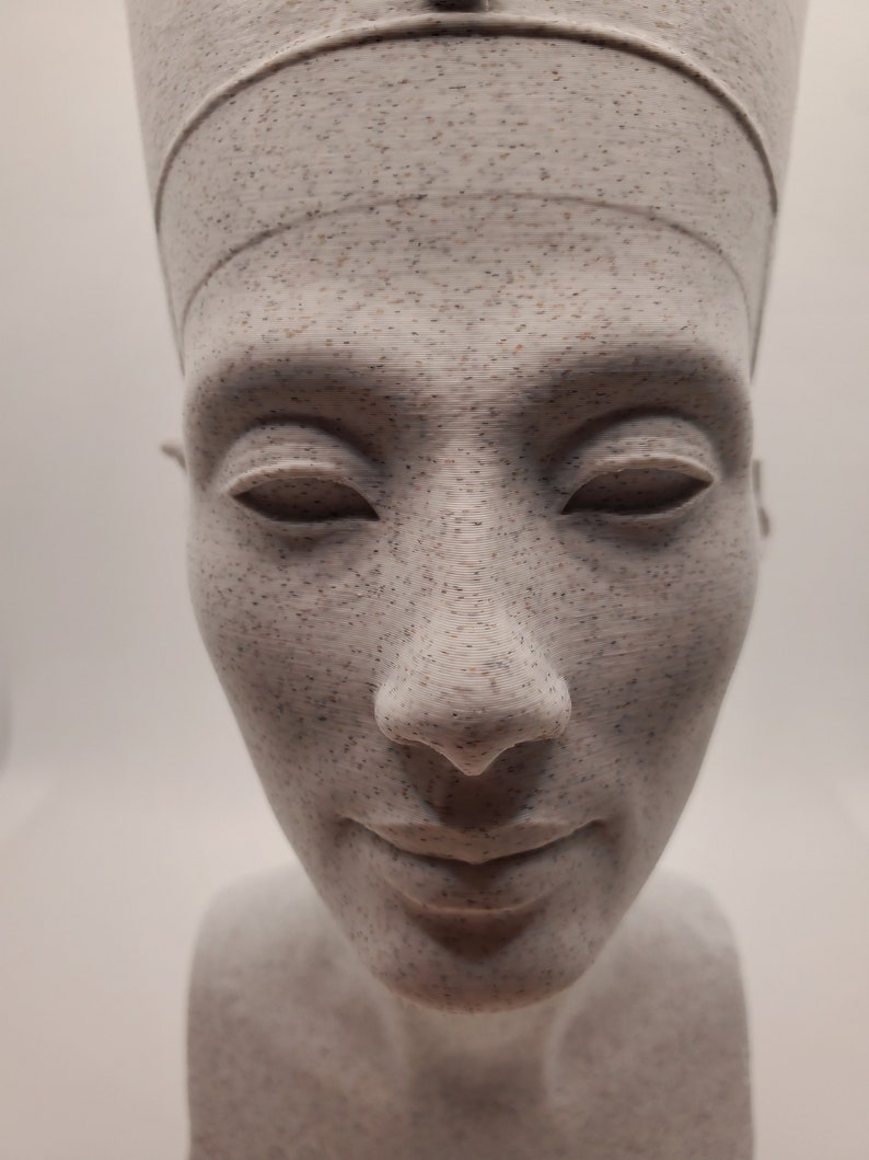 K&ouml;nnte beinhalten: Eine wei&szlig;e B&uuml;ste einer Frau mit Kopfbedeckung. Die Skulptur hat ein detailliertes Gesicht mit geschlossenen Augen und einem dezenten L&auml;cheln.