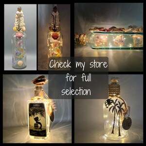 May include: A collage of decorative glass bottles with string lights. Some bottles are adorned with seashells and other nautical elements. One bottle features the text "Florida Mermaid Rum". The text "Check my store for full selection" is also visible.