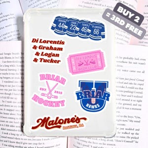 May include: A clear phone case covered in stickers. The stickers feature blue hockey jerseys with player names and numbers, a pink ticket, and pink and blue Briar Hockey and Hawks logos. The text "Malone's Hastings, MA" is also visible.