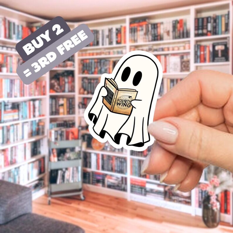 May include: A white ghost sticker reading a book titled "Fourth Wing." The sticker is held in front of a bookshelf. A banner above the sticker reads "BUY 2 = 3RD FREE."