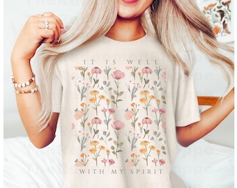 May include: A white t-shirt with a floral pattern and the text "It is well with my spirit" printed on the front. The shirt is made of a soft, comfortable material and is perfect for everyday wear.
