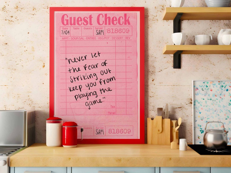 Peut inclure: Un ch&egrave;que de restaurant encadr&eacute; rose avec une citation motivationnelle manuscrite : "ne laissez jamais la peur de frapper un home run vous emp&ecirc;cher de jouer le jeu".