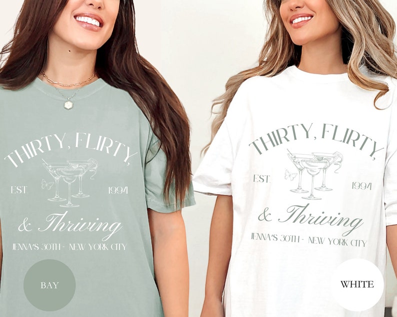 May include: Two t-shirts with the text "Thirty, flirty, est 1994 & Thriving" and a graphic of three martini glasses. The text "Jenna's 30th - New York City" is also included. One shirt is a light green color and the other is white.