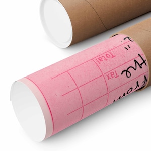 Peut inclure: Un rouleau de papier rose &agrave; motif quadrill&eacute; est partiellement ins&eacute;r&eacute; dans un tube en carton brun. Le tube porte une inscription manuscrite indiquant "From" et "Tax" avec une ligne pour "Total".
