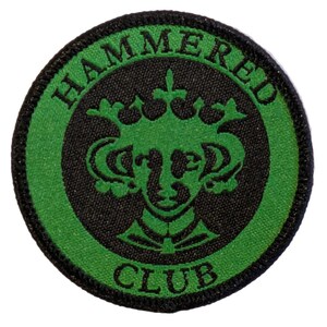 May include: A green and black embroidered patch with the text "HAMMERED CLUB" and a stylised image of a crowned figure.