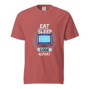 May include: Red t-shirt with the text "Eat Sleep Code Repeat" in white. A blue computer monitor with a pixelated design is in the centre of the shirt.