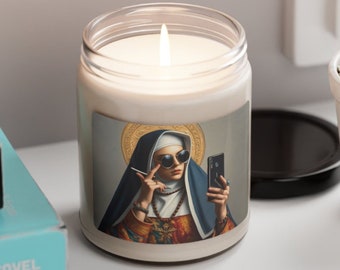 May include: A white candle in a glass jar with a printed image of a woman wearing a nun's habit, sunglasses, and holding a phone. The woman is holding a cigarette in her other hand.
