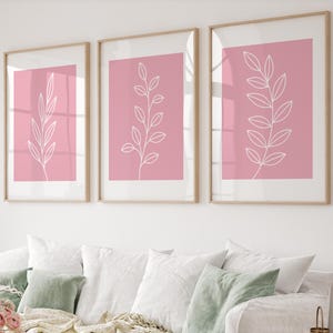 May include: Three framed prints with a pink background and white line drawings of stylized branches with leaves.