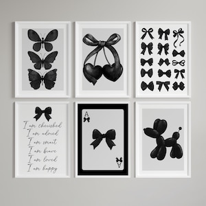 Può includere: Sei stampe artistiche in bianco e nero incorniciate. Le stampe presentano illustrazioni di farfalle, fiocchi e ciliegie, una collezione di fiocchi, il testo "I am cherished...happy", una carta da gioco con un fiocco e un cane fatto di palloncini.