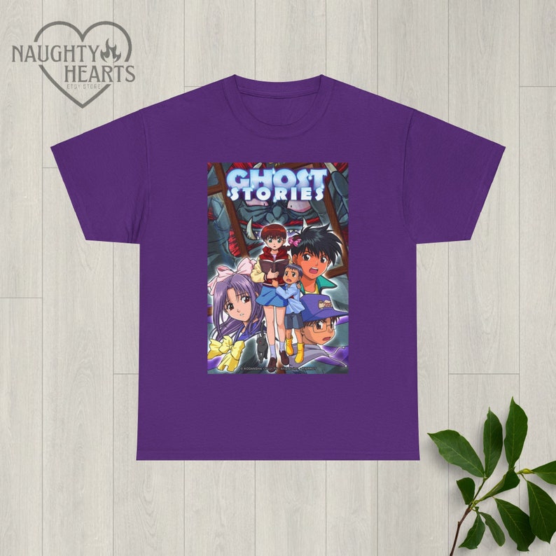 May include: Purple t-shirt with a graphic print of the anime Ghost Stories. The graphic features a group of characters from the show, including a girl with purple hair and a boy with brown hair.