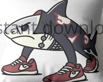May include: White pillow with a cartoon shark design. The shark is wearing a dark gray outfit with red accents and red sneakers. The shark has an angry expression.