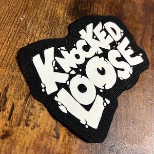 May include: Black and white patch with the text "Knocked Loose" in a bold, stylised font.