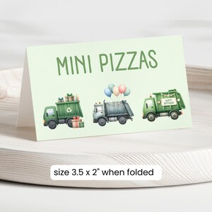 May include: Green and white mini pizza food labels with a cartoon illustration of a garbage truck with balloons and presents. The text on the label says "MINI PIZZAS". The label is 3.5 inches by 2 inches when folded.