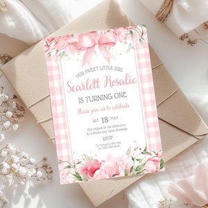 May include: Pink and white gingham patterned invitation with floral accents. The text reads "Our sweet little girl Scarlett Rosalie is turning one. Please join us to celebrate. Sat 18 May. One o'clock in the afternoon. At 4 Wildflower Lane, Rosedale. RSVP to Tatyle by 15th May on (305) XXX XXXX"