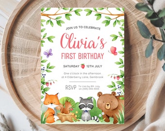 May include: A watercolor invitation for Olivia's first birthday, featuring forest animals and foliage. The invitation includes the text "Olivia's First Birthday" and event details. The design is set on a wooden tray.