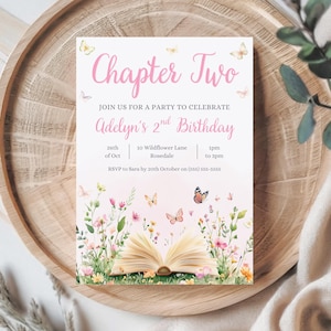 Puede incluir: Una invitación de fiesta rosa y blanca con el texto "Chapter Two". La invitación es para el segundo cumpleaños de Adelyn, con los detalles de la fecha, hora y lugar. El diseño incluye mariposas y un libro abierto con ilustraciones florales.