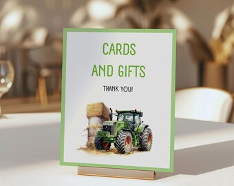 Könnte beinhalten: Ein grüner und schwarzer Traktor mit einer Heuballe im Hintergrund. Ein Schild mit der Aufschrift "Karten und Geschenke Danke!"