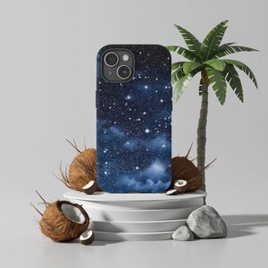 May include: A black phone case with a starry night sky design. The case is surrounded by coconuts and a palm tree.