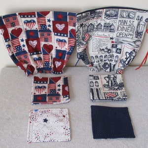 May include: Set of five red, white, and blue fabric coasters with a patriotic theme. Two coasters feature a patchwork design with stars, hearts, and stripes. Two coasters feature a black and white illustration of a diner with the text "Main St. Diner Open 24hrs". One coaster is solid blue with white polka dots.