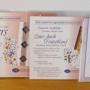 Puede incluir: Cuatro paquetes de pegatinas Creative Memories. Los paquetes presentan los títulos "Pacific Garden", "Stickers", "Deutsche Aufkleber" y "Harvest Orchard Laser Stickers". Las pegatinas están en fundas de plástico transparente.