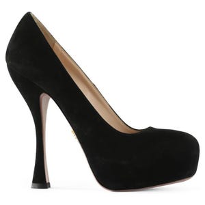 May include: Black suede platform pump with a rounded toe and a high, curved heel. The heel is approximately 4 inches tall. The shoe has a smooth, matte finish and a neutral-colored sole.