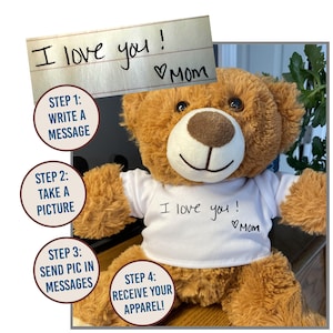 May include: A brown teddy bear wearing a white t-shirt with the message "I love you! Mom" written on it. The bear is sitting on a wooden surface. There are four steps outlined in circles around the bear, explaining how to personalize a t-shirt with a message.
