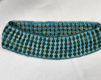Può includere: Un collo lavorato a mano a maglia nei toni del blu e del verde oliva. Il collo presenta un motivo geometrico ripetuto e un bordo smerlato. La sezione superiore ha un design più aperto e traforato. L'accessorio è realizzato in filato morbido.