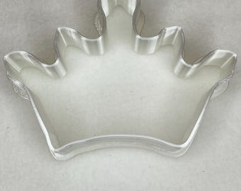 Può includere: Tagliapasta a forma di corona in plastica trasparente. Il tagliapasta ha un design dettagliato con più punte e un bordo liscio e arrotondato. Progettato per cuocere e decorare biscotti.