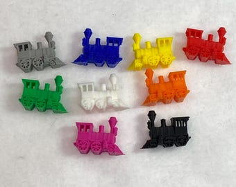 Può includere: Set di dieci pezzi di locomotive da treno in miniatura in vari colori, tra cui rosso, blu, giallo, verde, bianco, arancione, grigio, nero e rosa. Ogni locomotiva ha un camino a forma di diamante e ruote.