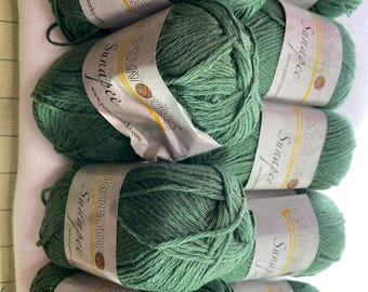 Può includere: Otto gomitoli di filato verde con etichette bianche che riportano "Patternworks Sunapee" e "www.patternworks.com".