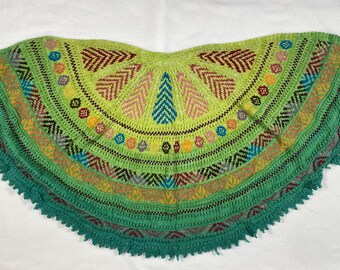 Può includere: Uno scialle all'uncinetto fatto a mano nei toni del verde, giallo e marrone. Lo scialle presenta intricati motivi geometrici e un bordo smerlato. Il design include motivi a spina di pesce e circolari.