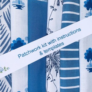 May include: A collection of folded fabric pieces in various shades of blue and white, featuring floral, striped, and checkered patterns. A white paper band is placed diagonally across the fabrics with the text Patchwork kit with instructions & templates.